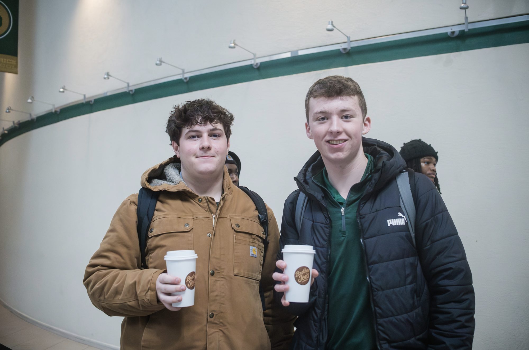 Two students holding Brother Joe's cups