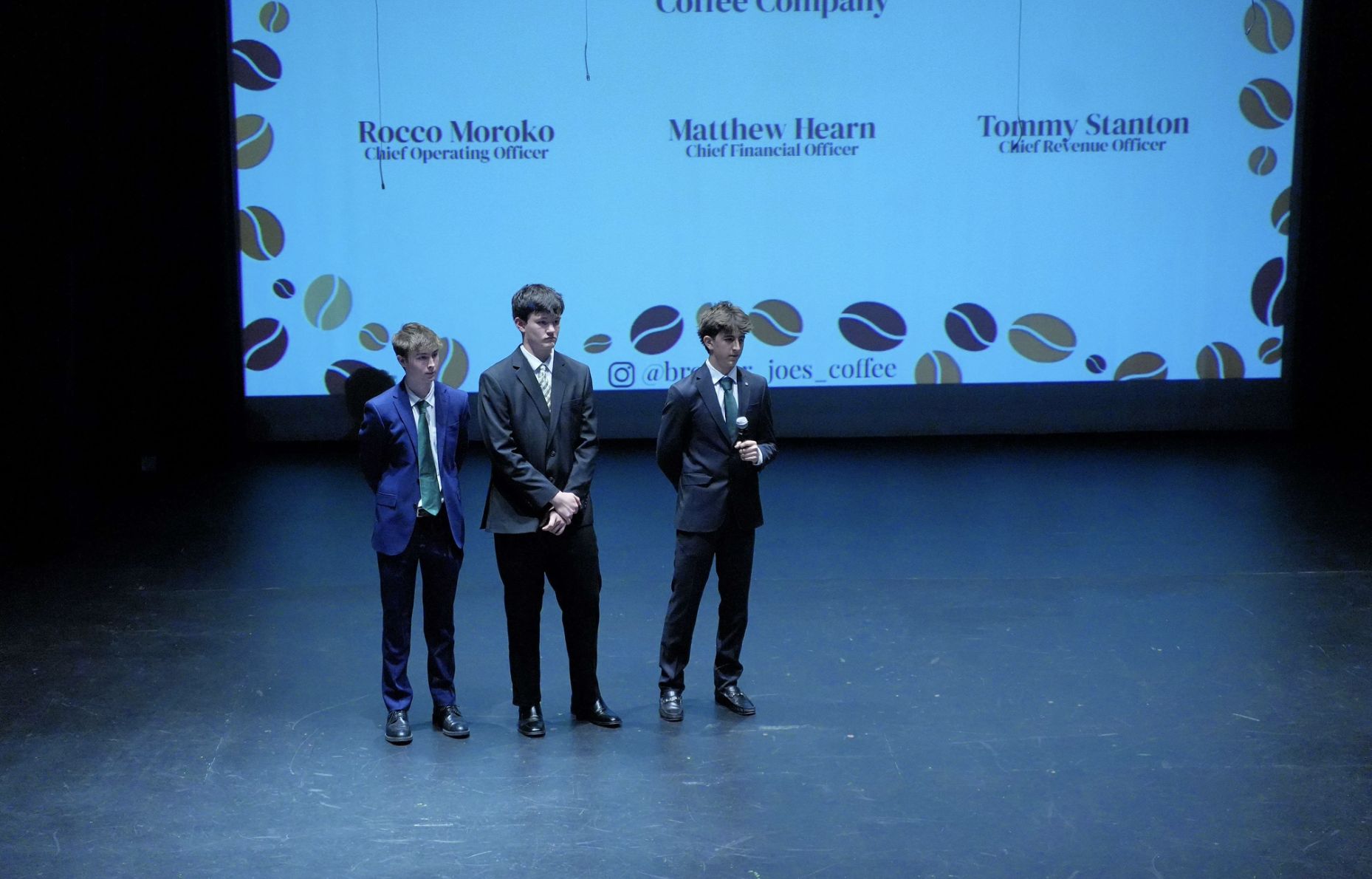 The three founders on stage in front of a slide with their names